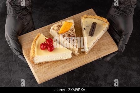 Klassischer Käsekuchen mit Kirschen auf dunklem Hintergrund. Stockfoto