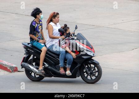 SAMUT PRAKAN, THAILAND, 02 2022. MÄRZ, Eine Frau fährt Kinder auf einem Motorrad. Stockfoto