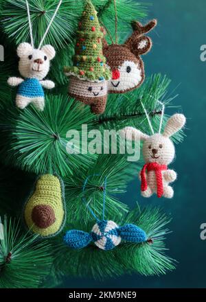 Handgemachtes Weihnachtsspielzeug an einem Baum. Süße Häkelschmuck-Dekoration Nahfoto. Umweltfreundliche Weihnachtsspielzeuge. Stockfoto