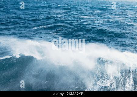 Das Boot weckt Wellen in der Drake Passage, wodurch Sprühnebel aus dem Wasser austritt. Stockfoto