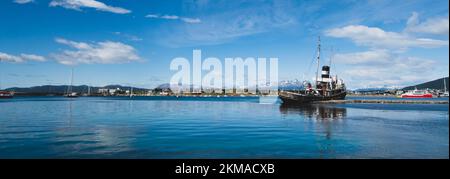 St. Christopher Schiffswrack mit Ushuaia Hafen und Andres Gebirge im Hintergrund. Das Ear-Schiff aus dem 2. Weltkrieg ist jetzt ein Denkmal für alle verlorenen Schiffe. Stockfoto