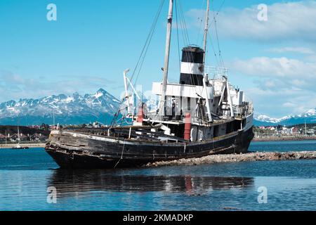 St. Christopher Schiffswrack mit Ushuaia Hafen und Andres Gebirge im Hintergrund. Das Ear-Schiff aus dem 2. Weltkrieg ist jetzt ein Denkmal für alle verlorenen Schiffe. Stockfoto