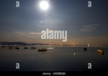 Boote bei Nacht im Mondschein auf dem Gardasee in Italien Stockfoto