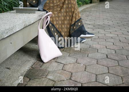 Frauen ließen ihre Handtasche am Strand Stockfoto