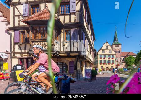 Turckheim (Türkheim): Rathaus, Kirche Sainte-Anne, Radfahrer im Elsass, Haut-Rhin (Oberelsass), Frankreich Stockfoto