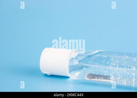 Flasche mit antiseptischem Handdesinfektionsmittel, durchsichtiges Gel, isoliert auf blauem Hintergrund, ohne Etikett. Antibakterielles, hydroalkoholisches Gel, Ethylalkohol. Stockfoto