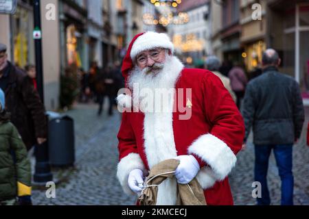 Naumburg, Deutschland. 26.. November 2022. Ein Weihnachtsmann geht in einer Einkaufsstraße in der Stadt Naumburg spazieren. Zahlreiche Institutionen sowie Geschäfts- und Privatleute öffnen ihre Gärten am ersten Adventswochenende in Naumburg. Besucher können Bereiche sehen, die ansonsten nicht sichtbar sind. Kredit: Frank Hammerschmidt/dpa/Alamy Live News Stockfoto