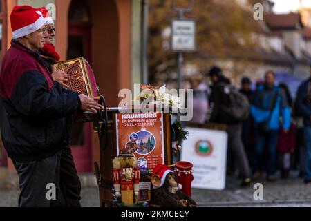 Naumburg, Deutschland. 26.. November 2022. Fass-Orgelspieler stehen in einer Straße und spielen Weihnachtsmusik. Zahlreiche Institutionen sowie Unternehmen und Privatpersonen öffnen ihre Höfe am ersten Adventswochenende in Naumburg. Besucher können Bereiche sehen, die ansonsten nicht sichtbar sind. Kredit: Frank Hammerschmidt/dpa/Alamy Live News Stockfoto