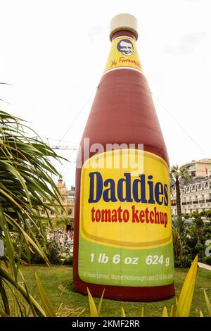 Eine riesige Flasche Daddies Tomatenketchup in den Casino Gardens, ein Kunstwerk, Daddies Tomatenketchup Inflatable, Skulptur, von Paul McCarthy, Künstler. Es ist Teil einer größeren Ausstellung, die viele Werke des Künstlers in einer Retrospektive seiner Kunst im Herzen des Fürstentums, Monte Carlo, Monaco, Südfrankreich, Frankreich, Frankreich, Europa, Europa, August, Sommer zeigt. Mittelmeer, Küste, Stadt, Staat, Land, reich, Millionäre, Stockfoto