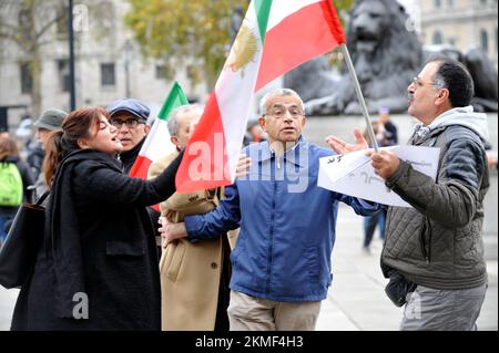 London, Großbritannien. 26.. November 2022. Eine Frau in schwarzem Mantel mit ihrer Gefährtin in Lederjacke soll die iranische Monarchie beleidigen. Die Frau im schwarzen Mantel schlug der blonden Frau ins Gesicht und wurde von der Polizei verhaftet. Iraner protestieren am Trafalgar Square. Protest in London über den Tod von Mahsa Amini in den Händen der iranischen Moralpolizei, weil sie ihren Hijab falsch getragen hat. Kredit: JOHNNY ARMSTEAD/Alamy Live News Stockfoto