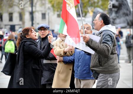 London, Großbritannien. 26.. November 2022. Eine Frau in schwarzem Mantel mit ihrer Gefährtin in Lederjacke soll die iranische Monarchie beleidigen. Die Frau im schwarzen Mantel schlug der blonden Frau ins Gesicht und wurde von der Polizei verhaftet. Iraner protestieren am Trafalgar Square. Protest in London über den Tod von Mahsa Amini in den Händen der iranischen Moralpolizei, weil sie ihren Hijab falsch getragen hat. Kredit: JOHNNY ARMSTEAD/Alamy Live News Stockfoto