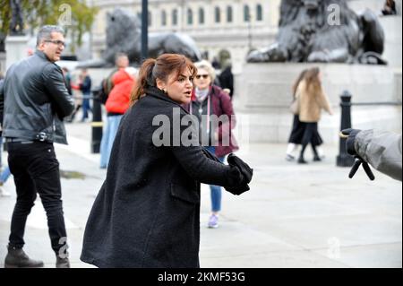 London, Großbritannien. 26.. November 2022. Eine Frau in schwarzem Mantel mit ihrer Gefährtin in Lederjacke soll die iranische Monarchie beleidigen. Die Frau im schwarzen Mantel schlug der blonden Frau ins Gesicht und wurde von der Polizei verhaftet. Iraner protestieren am Trafalgar Square. Protest in London über den Tod von Mahsa Amini in den Händen der iranischen Moralpolizei, weil sie ihren Hijab falsch getragen hat. Kredit: JOHNNY ARMSTEAD/Alamy Live News Stockfoto