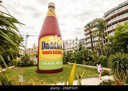 Eine riesige Flasche Daddies Tomatenketchup in den Casino Gardens, ein Kunstwerk, Daddies Tomatenketchup Inflatable, Skulptur, von Paul McCarthy, Künstler. Es ist Teil einer größeren Ausstellung, die viele Werke des Künstlers in einer Retrospektive seiner Kunst im Herzen des Fürstentums, Monte Carlo, Monaco, Südfrankreich, Frankreich, Frankreich, Europa, Europa, August, Sommer zeigt. Mittelmeer, Küste, Stadt, Staat, Land, reich, Millionäre, Stockfoto