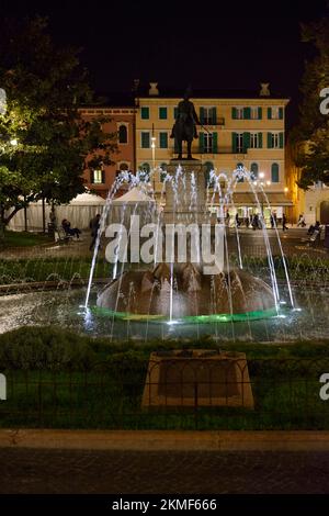 Piazza Bra mit Alpenbrunnen und Reiterstatue bei Nacht in Verona, Italien. Stockfoto