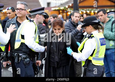 London, Großbritannien. 26.. November 2022. Eine Frau in schwarzem Mantel mit ihrer Gefährtin in Lederjacke soll die iranische Monarchie beleidigen. Die Frau im schwarzen Mantel schlug der blonden Frau ins Gesicht und wurde von der Polizei verhaftet. Iraner protestieren am Trafalgar Square. Protest in London über den Tod von Mahsa Amini in den Händen der iranischen Moralpolizei, weil sie ihren Hijab falsch getragen hat. Kredit: JOHNNY ARMSTEAD/Alamy Live News Stockfoto