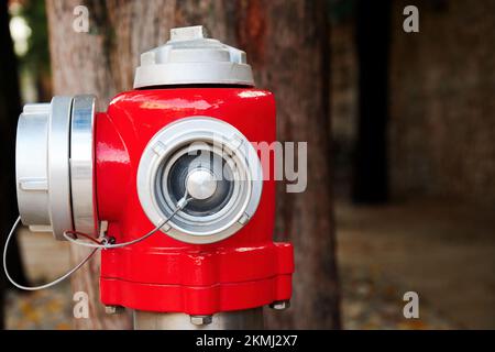 Roter öffentlicher Hydrant auf der Straße. Brandversorgungen und Ausrüstung für die Sicherheit in der Stadt Stockfoto