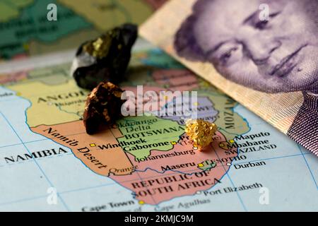 Nahaufnahme einer Yuan-chinesischen Banknote und Seltenerdmetalle auf einer Karte von Afrika Stockfoto