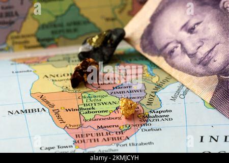 Nahaufnahme einer Yuan-chinesischen Banknote und Seltenerdmetalle auf einer Karte von Afrika Stockfoto