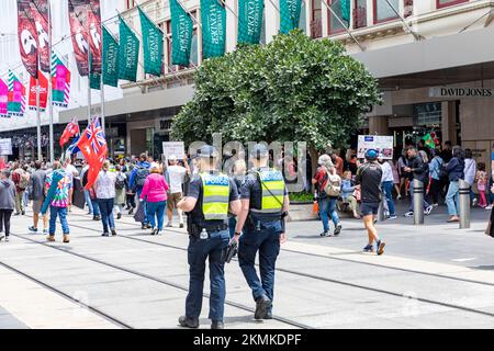 Viktorianische Polizisten gehen hinter einem Protest gegen die Impfung von Covid in Melbourne City Centre,Victoria,Australien , Protest gegen Impfstoffe covid Stockfoto