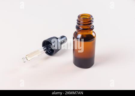 Kleines, offenes Tropfflaschen-Modell mit brauner Pipette und schwarzem Deckel Stockfoto