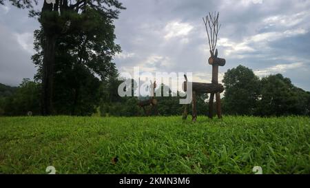 Unglaubliche hölzerne Hirsche in einem wunderschönen Garten Stockfoto