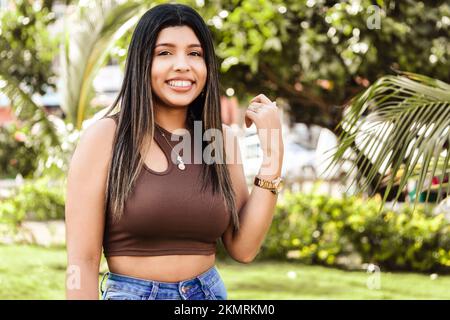 Eine junge hispanische Frau, die draußen lächelt Stockfoto