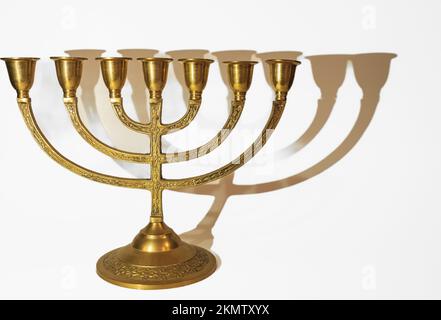 Alte Kerzenmenora auf weißem Hintergrund. Wunderschöne goldene chanukka Menorah. Jüdisches Feiertagsbanner mit Kopierraum Stockfoto