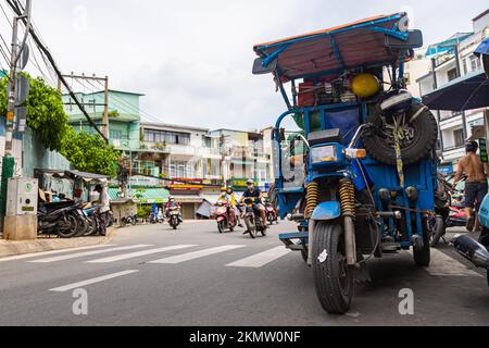 Ho-Chi-Minh-Stadt, Vietnam - 8. November 2022: Cargo-Motorrad oder Trike auf dem Gehweg einer Gasse im 5. Bezirk von Saigon. Andere Krafträder, die b passieren Stockfoto