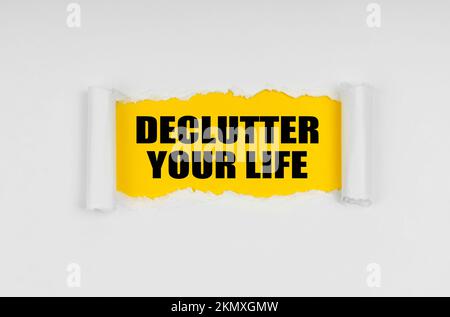 Geschäfts- und Finanzkonzept. In der Zeitung ist ein Fenster gefertigt, in dem auf gelbem Hintergrund die Inschrift "Declutter Your Life" steht Stockfoto