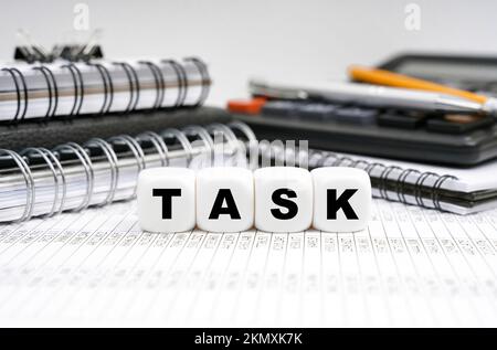 Geschäfts- und Finanzkonzept. Auf dem Tisch, unter Büroobjekten, Würfel mit der Inschrift - TASK Stockfoto