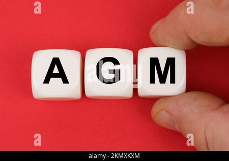 Wirtschaft und Finanzen. Auf der roten Oberfläche weiße Würfel mit der Aufschrift - AGM Stockfoto