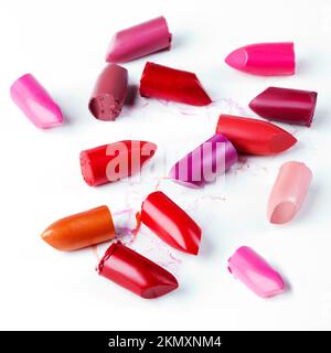 Lass deine Lippen die Leinwand sein. Lippenstifte liegen locker vor einem weißen Hintergrund. Stockfoto