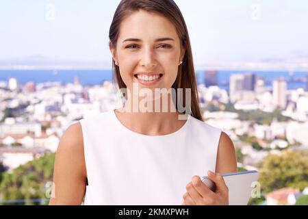 Das Geschäft ein paar Stufen höher. Porträt einer hübschen Frau, die auf dem Balkon steht und lächelt. Stockfoto