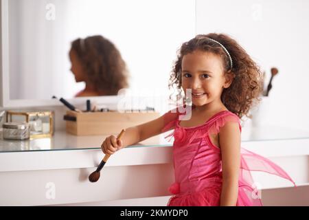 Ich werde genauso aussehen wie meine Mami. Porträt eines kleinen Mädchens, das vor dem Spiegel mit Make-up spielt. Stockfoto