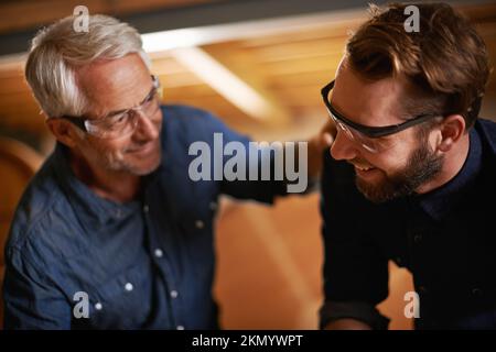 Zusammen könnten sie die Welt verändern. Vater und Sohn arbeiten in einer Werkstatt zusammen. Stockfoto