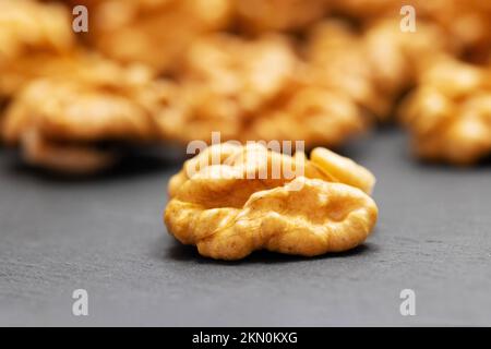 Walnüsse. Walnusskerne auf einem Tisch aus dunklem Stein. Vegetarische oder gesunde Lebensmittel Stockfoto