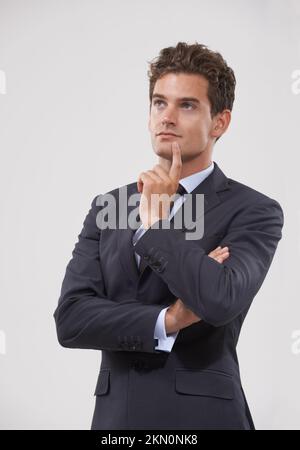 Neue Geschäftsstrategien entwickeln. Ein gutaussehender junger Geschäftsmann, der aufmerksam aussieht, mit der Hand am Kinn. Stockfoto
