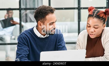 Geschäftskollegen, die in einem geschäftigen Großraumbüro arbeiten. Stockfoto