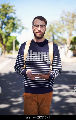 Der Inbegriff von Geek trifft auf Hip trifft auf den modernen Hipster. Ein hübscher junger Hipster im Freien, während er eine Brille trägt. Stockfoto