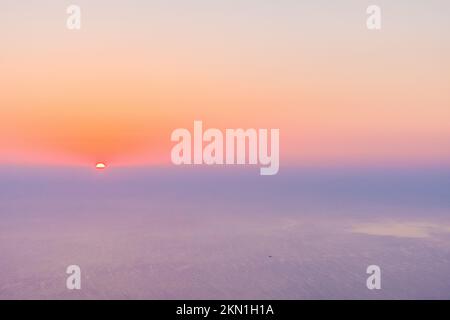 Wolkiger Himmel mit Sonnenuntergang am Horizont. Stockfoto