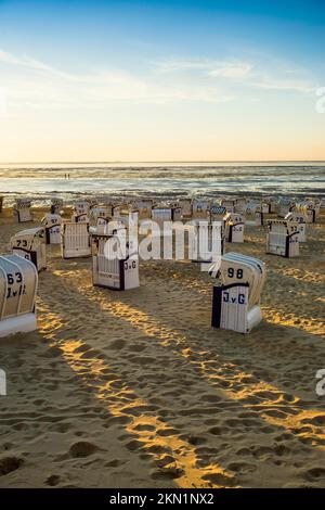 Weiße Strandstühle und Schlammgebiete, Sonnenuntergang, Duhnen, Cuxhaven, Nordsee, Niedersachsen, Deutschland, Europa Stockfoto