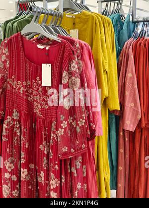 Legere Damenbekleidung in einer Boutique, Kleidung mit einer Auswahl an Damenmode, bunte Damenkleider auf Kleiderbügeln in einem Einzelhandelsgeschäft in Indien. Stockfoto