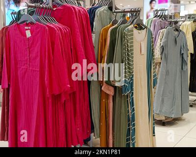 Legere Damenbekleidung in einer Boutique, Kleidung mit einer Auswahl an Damenmode, bunte Damenkleider auf Kleiderbügeln in einem Einzelhandelsgeschäft in Indien. Stockfoto