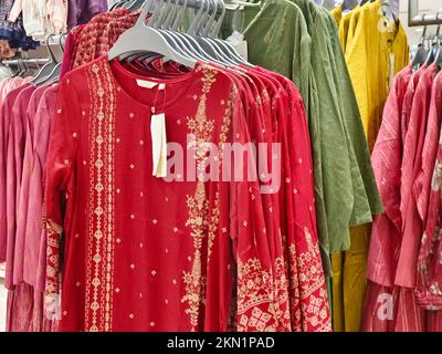 Legere Damenbekleidung in einer Boutique, Kleidung mit einer Auswahl an Damenmode, bunte Damenkleider auf Kleiderbügeln in einem Einzelhandelsgeschäft in Indien. Stockfoto