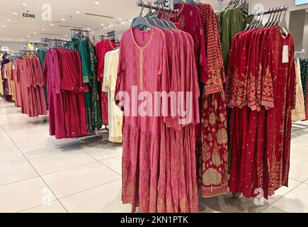 Legere Damenbekleidung in einer Boutique, Kleidung mit einer Auswahl an Damenmode, bunte Damenkleider auf Kleiderbügeln in einem Einzelhandelsgeschäft in Indien. Stockfoto