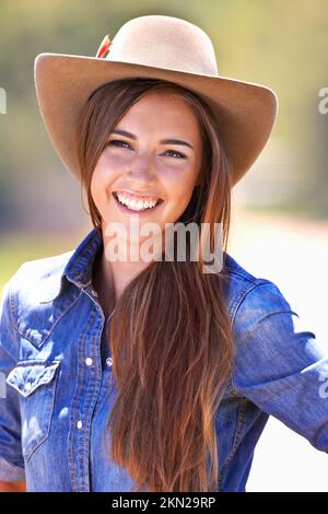 Hallo, Partner. Eine wunderschöne junge Frau in einem Cowgirl-Outfit, die draußen steht. Stockfoto