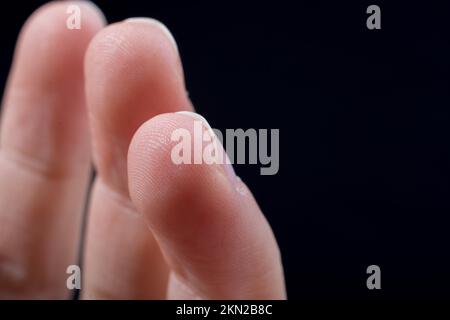Drei Finger einer Hand des Kindes teilweise in schwarzen Hintergrund gesehen Stockfoto
