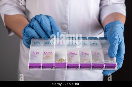 Ärztliche Verschreibung und Apothekenkonzept. Tablettenhülle, Tablettenorganisator, Vitaminbox in Arzthandlungen. Hochwertiges Foto Stockfoto