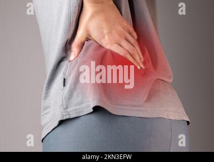 Lendenwirbelschmerzen im unteren Rücken, Schmerzen. Schmerzhafte Lende. Frau mit Rückenproblemen, Rückenschmerzen. Hochwertiges Foto Stockfoto