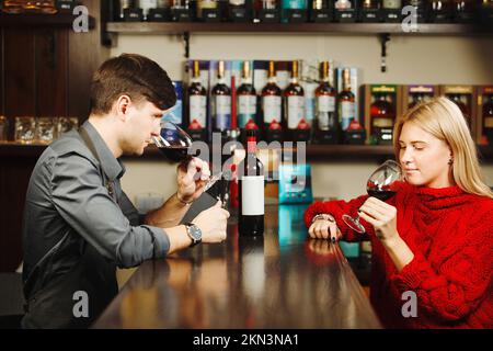 Barkeeper und Besucher riechen Weinaroma aus Gläsern Stockfoto